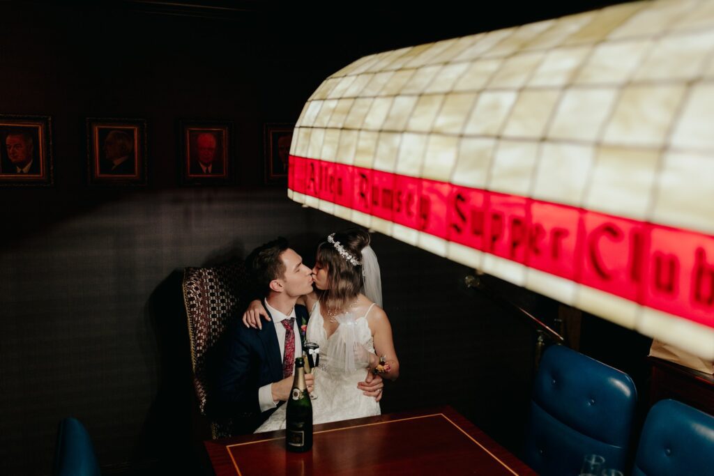 Bride and Groom kissing inside the Allen Rumsey Supper Club at The Graduate Ann Arbor